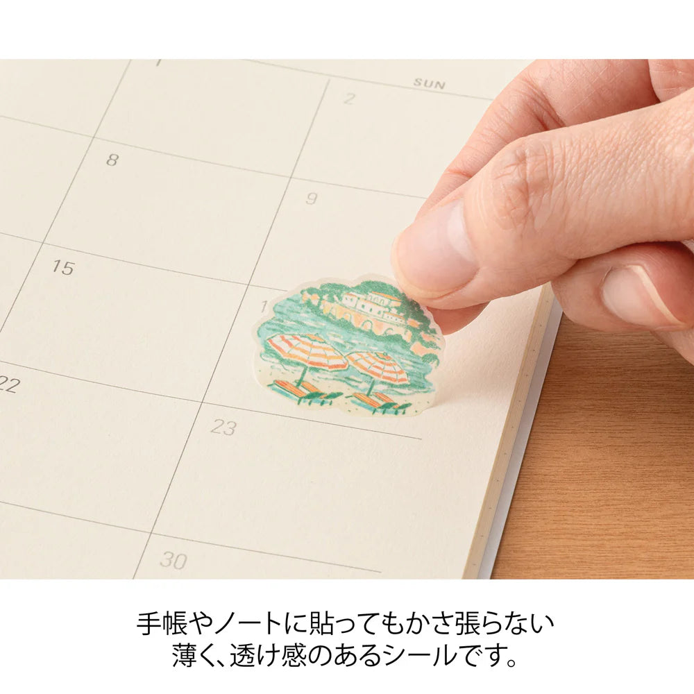 Hand placing a decorative sticker on a calendar page