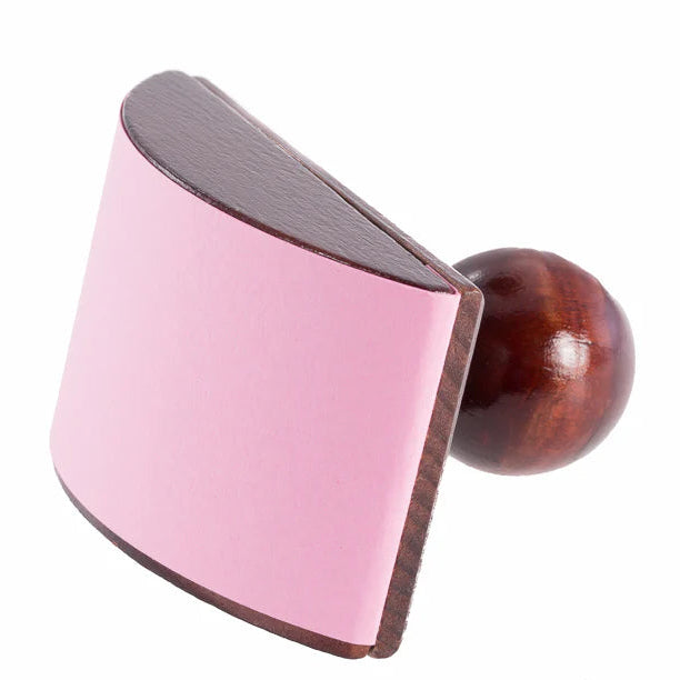 Wooden block with handled pink blotting paper on a white background