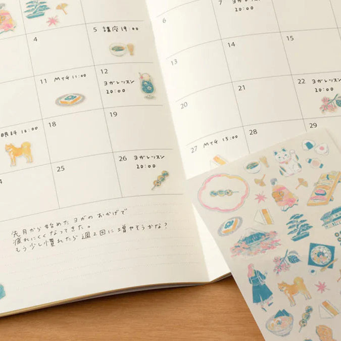 Calendar with stickers featuring various illustrations on a wooden surface